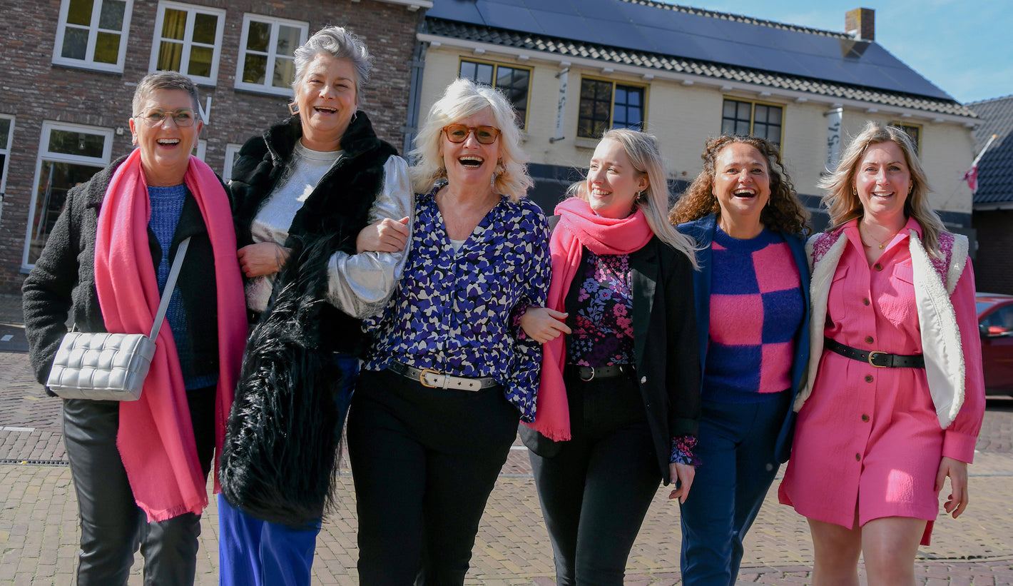 Foto van het team van LNPN, samen lopen zij naar de camera toe met op de achtergrond de winkels